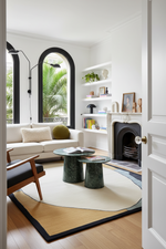 Modern living room with white walls, a fireplace, and decorative contemporary rug.