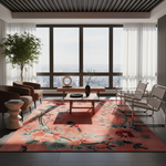 A large rectangular area rug with a pink, coral, and orange floral pattern and green leaves, styled in a modern living room with a city view through large windows.