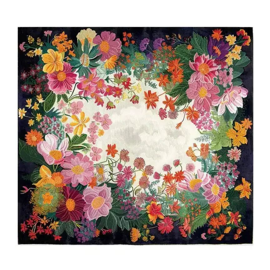 A square floral tapestry or wall hanging with a dense border of colorful flowers around a central white square, set against a dark background.