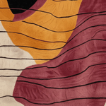 Abstract patterned textile close-up with flowing organic shapes in mustard yellow, burgundy, cream, and black linear texture.