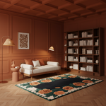 A styled living room with warm terracotta wood paneling and ceiling, featuring a white sofa with orange and white pillows, a large floral area rug, a dark wood bookcase filled with books, and two floor lamps.