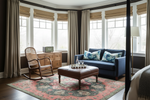 Living room with a blue sofa, armchair, ottoman, and decorative rug.