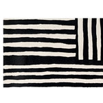 A contemporary wool runner rug featuring bold black and white stripes in an abstract pattern. Perfect for adding a modern touch to kitchens, hallways, or bathrooms, this hand-tufted rug combines style and functionality.