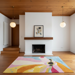 A colorful abstract area rug in shades of pink, yellow, blue, and cream is styled in a modern living room with a white fireplace, wood ceiling, and two hanging globe lights.
