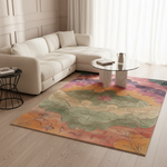 A colorful area rug with an abstract floral pattern in shades of orange, green, pink, and purple, styled in a bright, modern living room with a cream sectional sofa and a glass coffee table.
