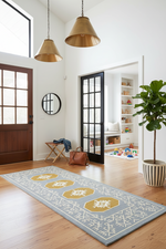 Living room with a patterned blue rug, wooden floor, and decorative elements.