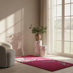 A bright magenta area rug with a leopard print pattern styled in a sunlit living room corner next to a gray armchair, with marble side tables and a potted plant.