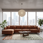 A modern sectional sofa in rust-brown velvet is arranged in a bright, contemporary living room with a city skyline view through large windows. The room includes a white paper lantern pendant light, a geometric patterned rug, a sculptural wooden coffee table, and potted plants.
