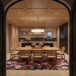 A modern dining room scene viewed through an arched doorway, featuring a light wood dining table and chairs on a large floral rug, with a kitchen in the background.