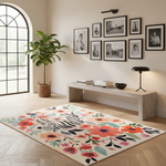 A large rectangular area rug with a cream background, a black-and-white zebra motif, and colorful floral patterns in coral, pink, orange, teal, and purple, styled in a bright modern living room next to a potted plant and a stone bench.